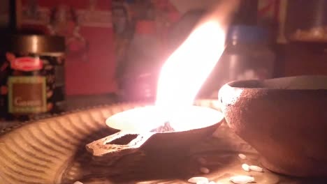 happy diwali - colorful metal diya lamps lit during diwali celebration. clay diya burning in from of god.