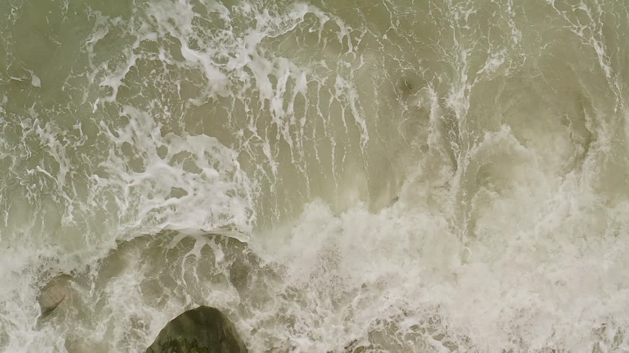 Aerial Top Down View of Slow-Motion Waves Over Rocks at Banbanon Beach, Philippines