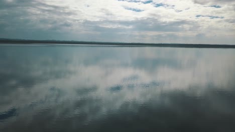 drone aerial flyover at a low altitude, revealing lake peten itza, el remate, guatemala