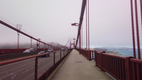 gimbal pov shot from a moving bike going across the golden gate bridge on a foggy day in san francisco, california