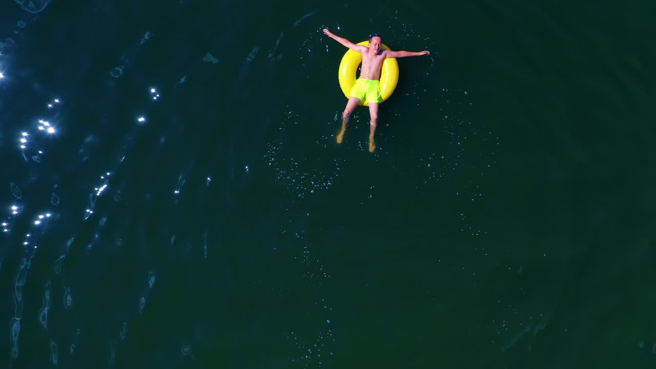 Boy swimming with swim ring. Happy little boy swimming with colorful ring