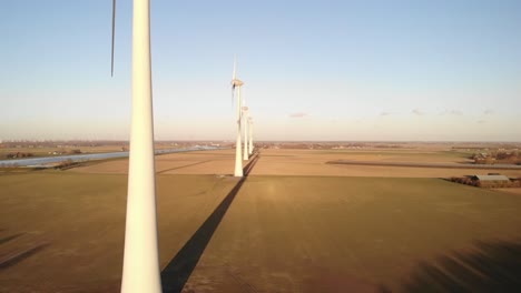 slow motion: moving wind turbines in a golden field