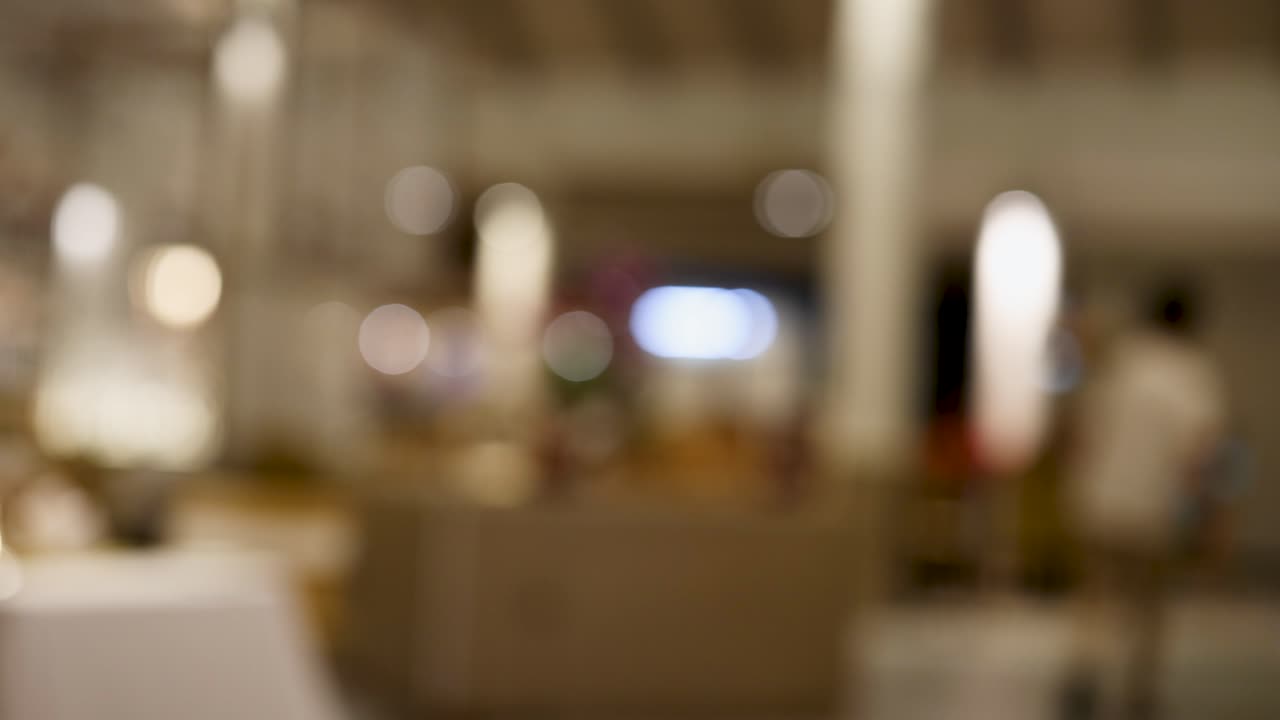 밤에 비는 태국 레스토랑의 흐릿한 시야, 주변 조명과 고객과 직원의 움직임을 포착합니다.