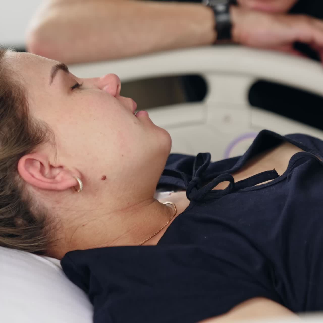 Fair-haired Caucasian woman lies in the hospital bed. Pregnant lady closes eyes as she feels pain from contractions. Close up