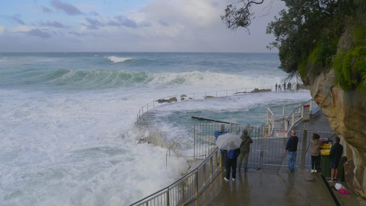 폭풍우 동안 거친 파도를 보는 사람들 - bronte baths - sydney, nsw, australia에서 넘치는 물