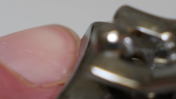 Macro close up of person cut off rough skin around the nail