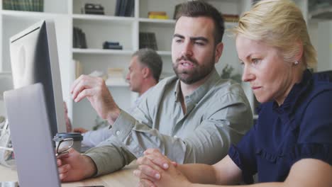 colleagues discussing about something on the computer