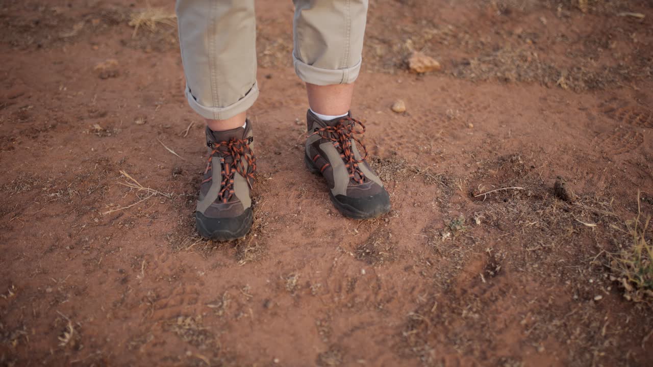 mujer anónima relajante caminando por el suelo en el desierto