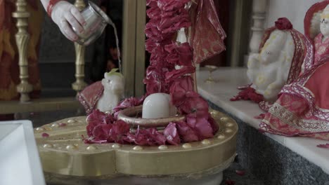 hindu god lord shivalinga prying by devotee with offering at temple at day