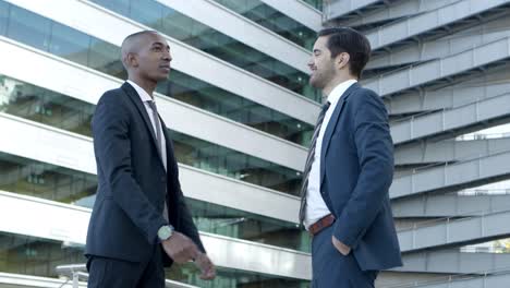 Cheerful-male-colleagues-greeting-each-other