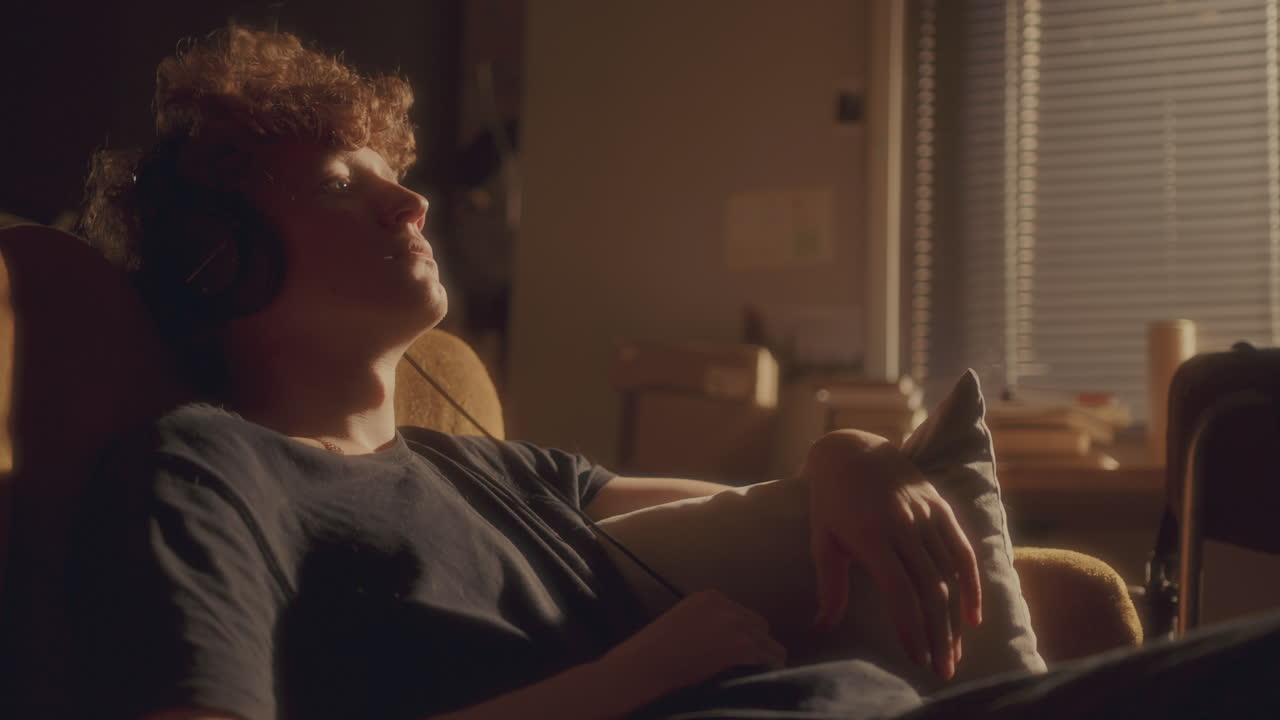 가정에서 음악을 듣고 있는 헤드폰을 착용한 감정적으로 소진된 남자