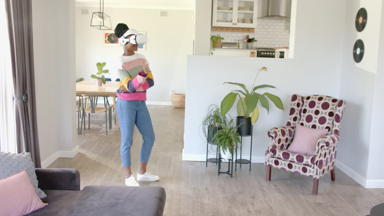 Using VR headset, woman exploring virtual reality in modern living room