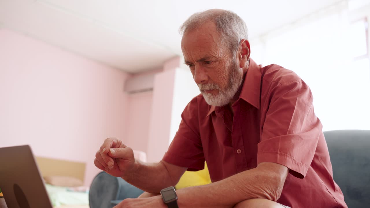 Senior man using a laptop at home