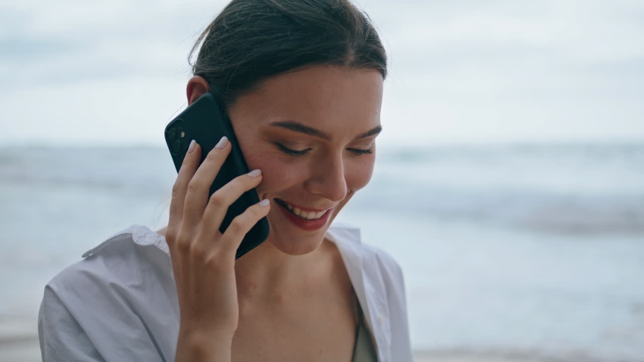 Smiling girl calling beach closeup. Woman talking by smartphone walking seashore