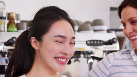 three female coffee shop owners at their cafe, close up