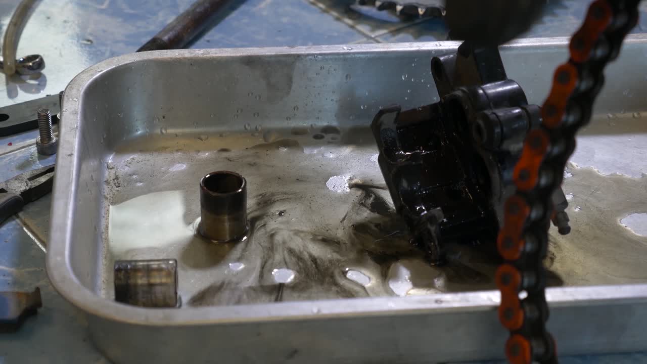 오토바이 브레이크 캘리퍼 청소 과정에서 작업하는 기술자의 클로즈업 영상