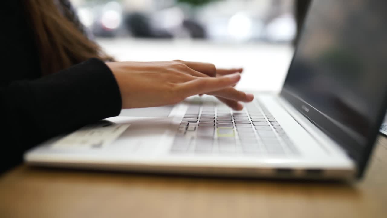 mujer trabajando en una computadora portátil en un café