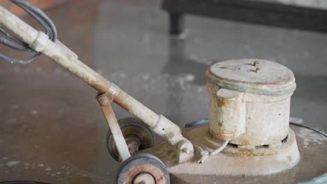 unrecognizable person uses sander for concrete on screed