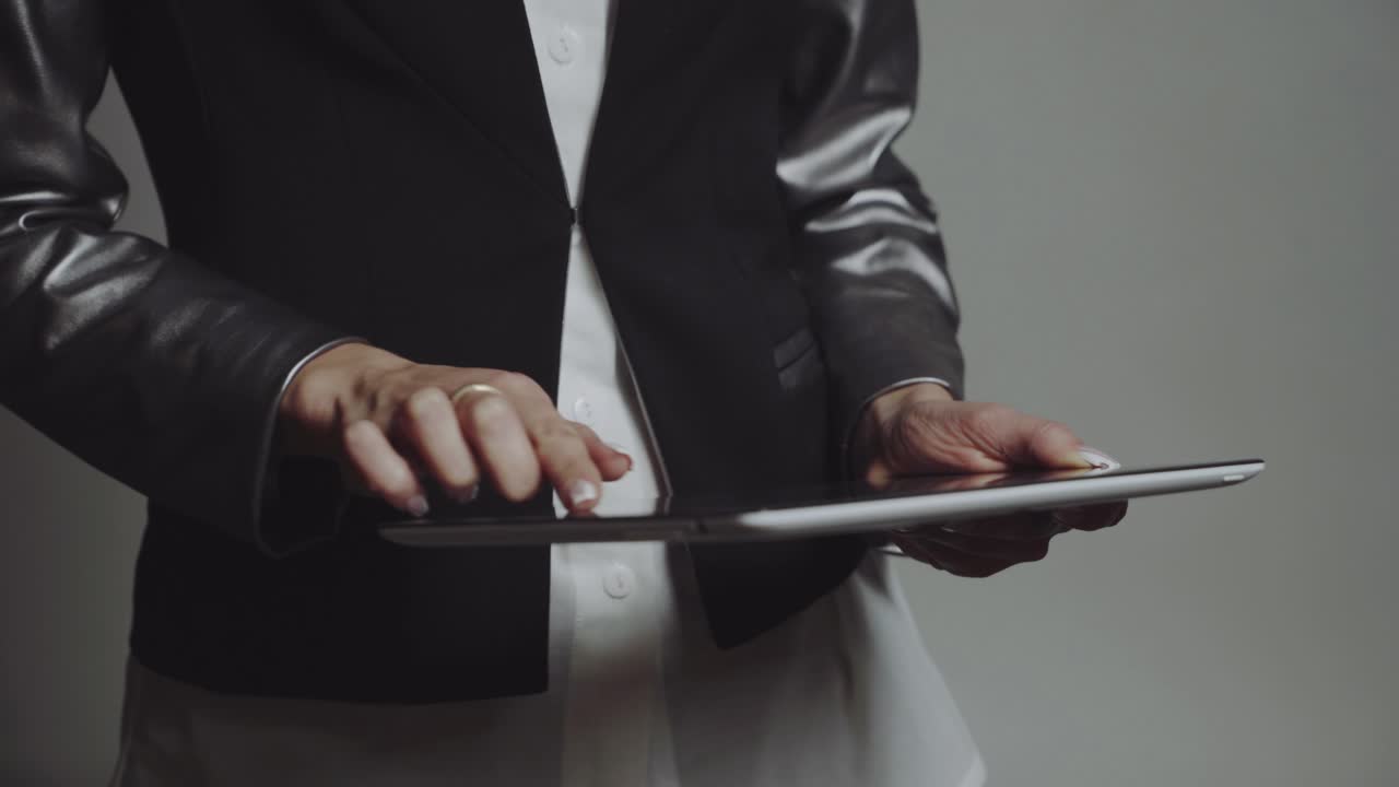 Girl with tablet in studio. Young business woman holding and working on tablet in studio