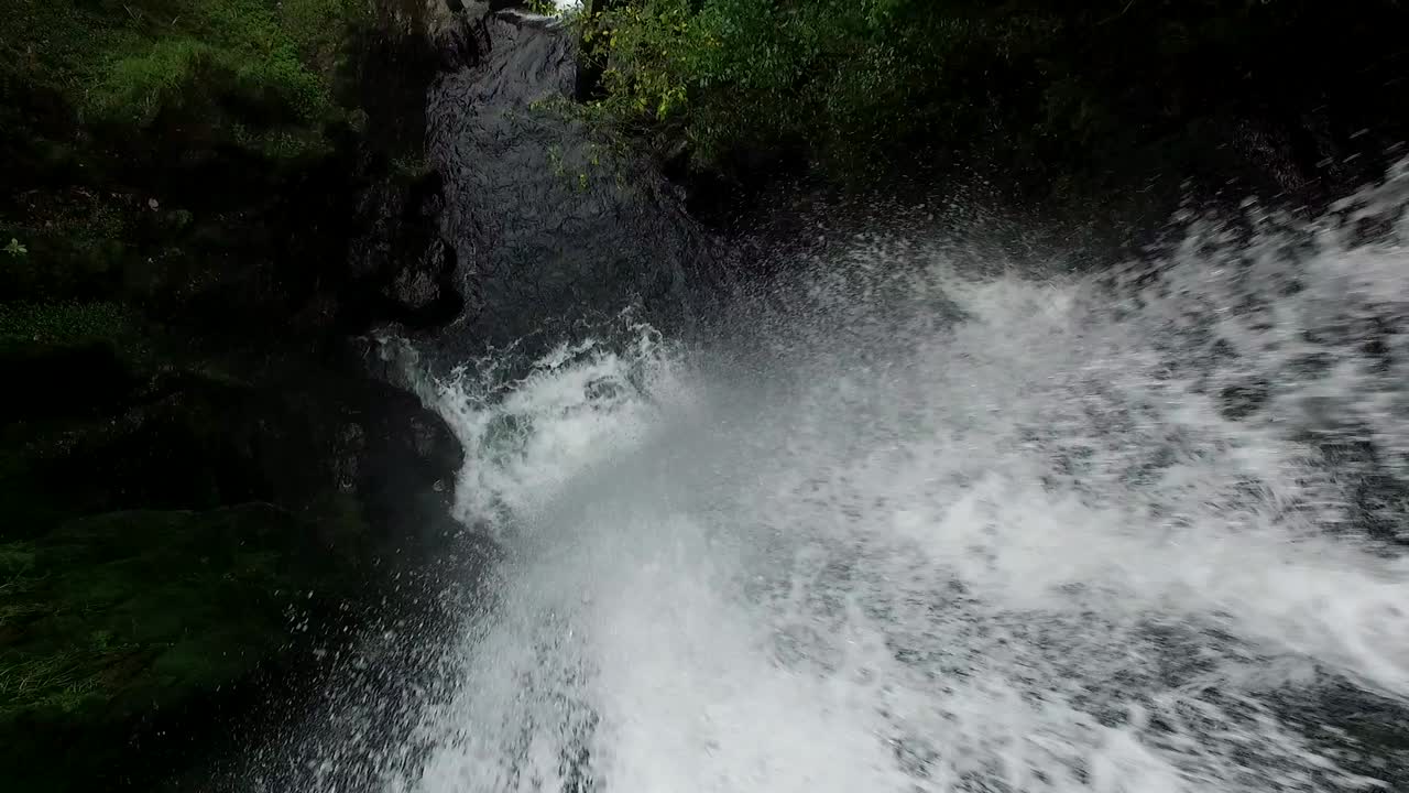 Aerial View of Water rushing down a massive Waterfall int the Jungle