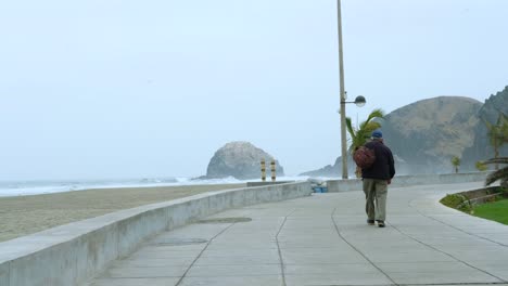 old man walking on the coast