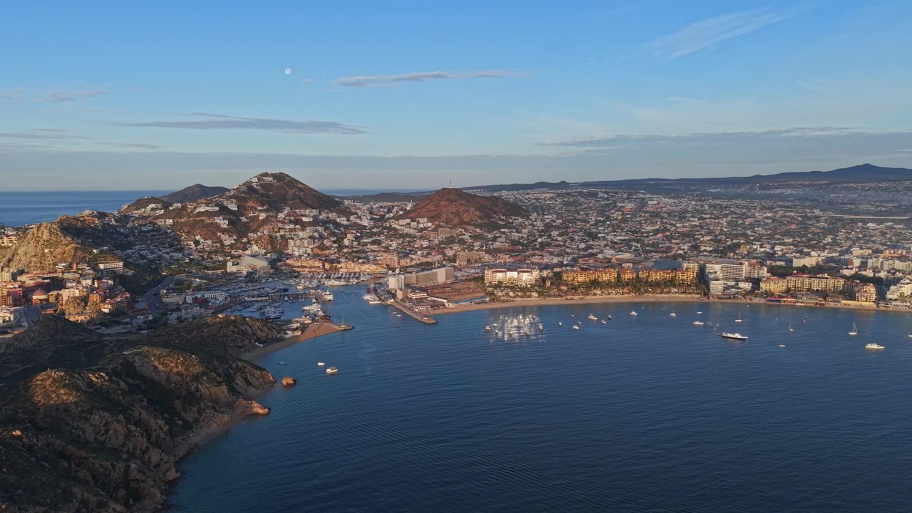 Vista aerea orbitale di Cabo San Lucas al tramonto, con il suo lussuoso porto pieno di yacht esclusivi, Baja California, Messico
