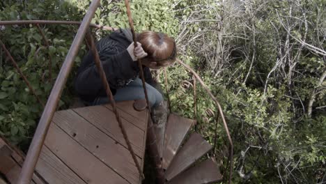 woman petting cat on spiral staircase