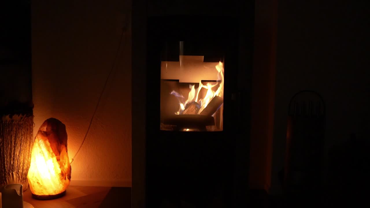 Glowing fireplace with a salt lamp casting warm light in a dimly lit cozy interior