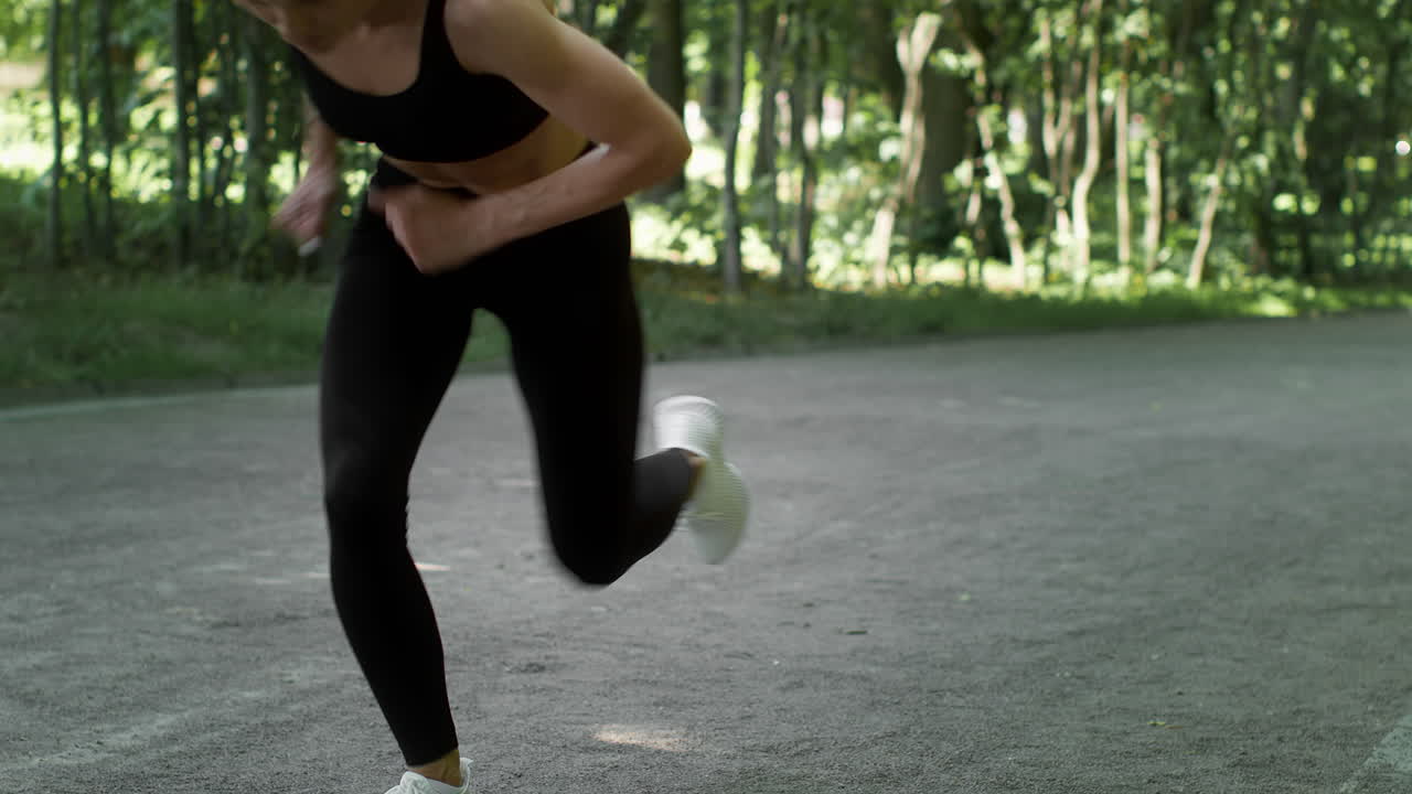 Woman in running starting position in a park