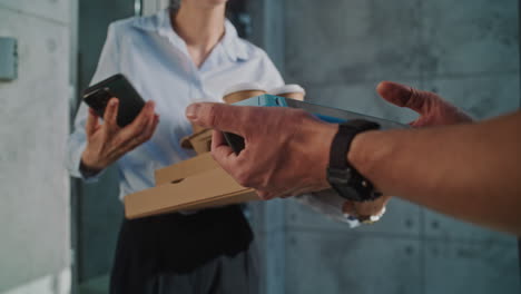customer completes payment for a food and coffee delivery using a payment terminal