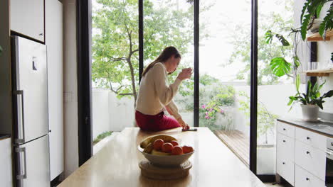 Young-Caucasian-transgender-woman-enjoys-a-beverage-at-home,-with-copy-space