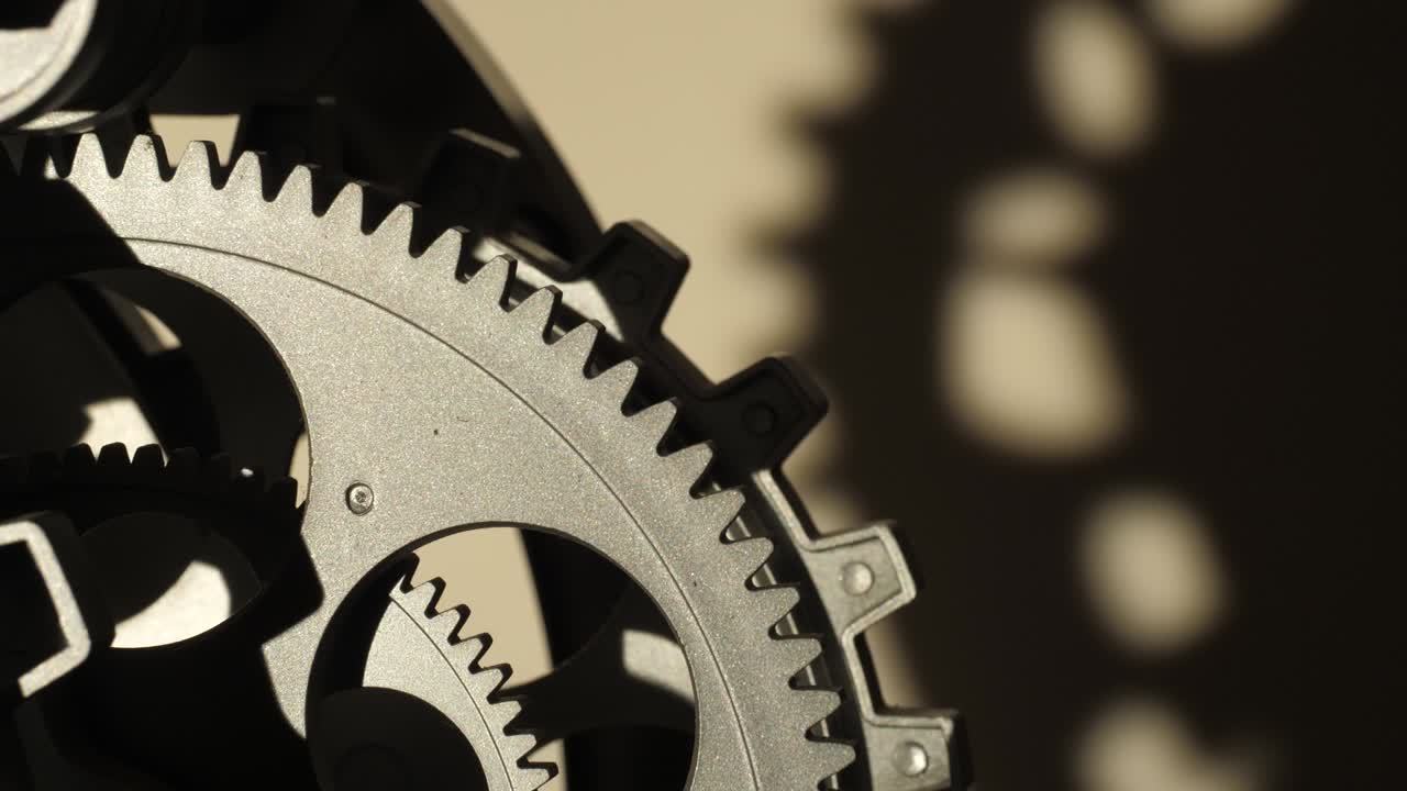 Close up cogwheels of an industrial looking clock shadows