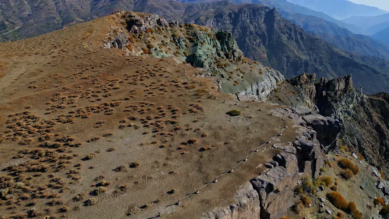 Veduta aerea di scogliere erose colorate con vegetazione rada su una cresta alpina