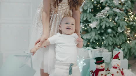 Portrait-of-smiling-baby-boy-dancing-with-present-box-in-modern-house.