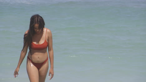 mujer latina despreocupada en bikini en un día soleado se baña en las cálidas aguas del océano caribeño