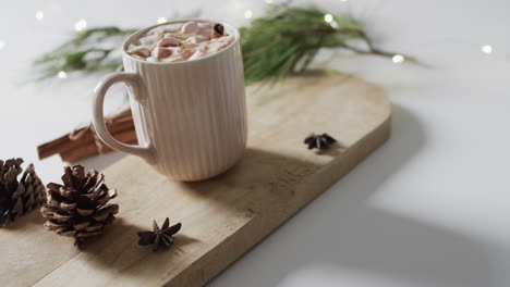 video of mug of christmas chocolate on wooden board and copy space on white background