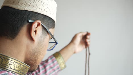 muslim man keep hand in praying gestures during ramadan, rear view