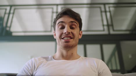 Portrait-of-smiling-man-looking-at-camera-at-home.-Joyful-man-talking-to-camera