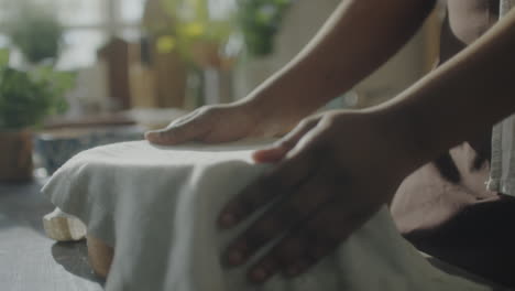 baking preparation: hands covering a bowl with a cloth