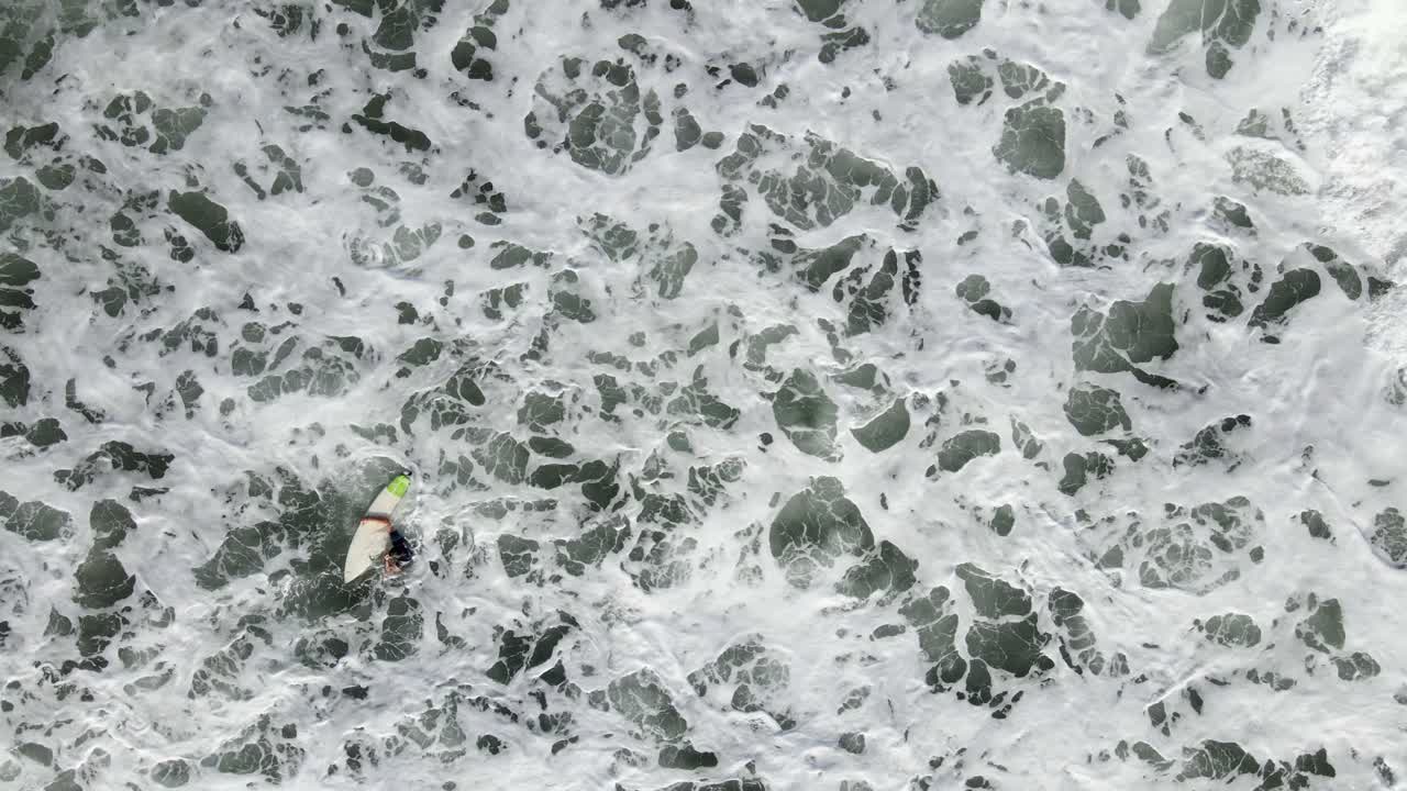 AERIAL - Surfer gets sucked into ocean with the tide