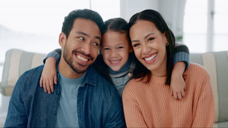 Mom,-dad-and-face-of-kid-hug-happy-parents-on-sofa