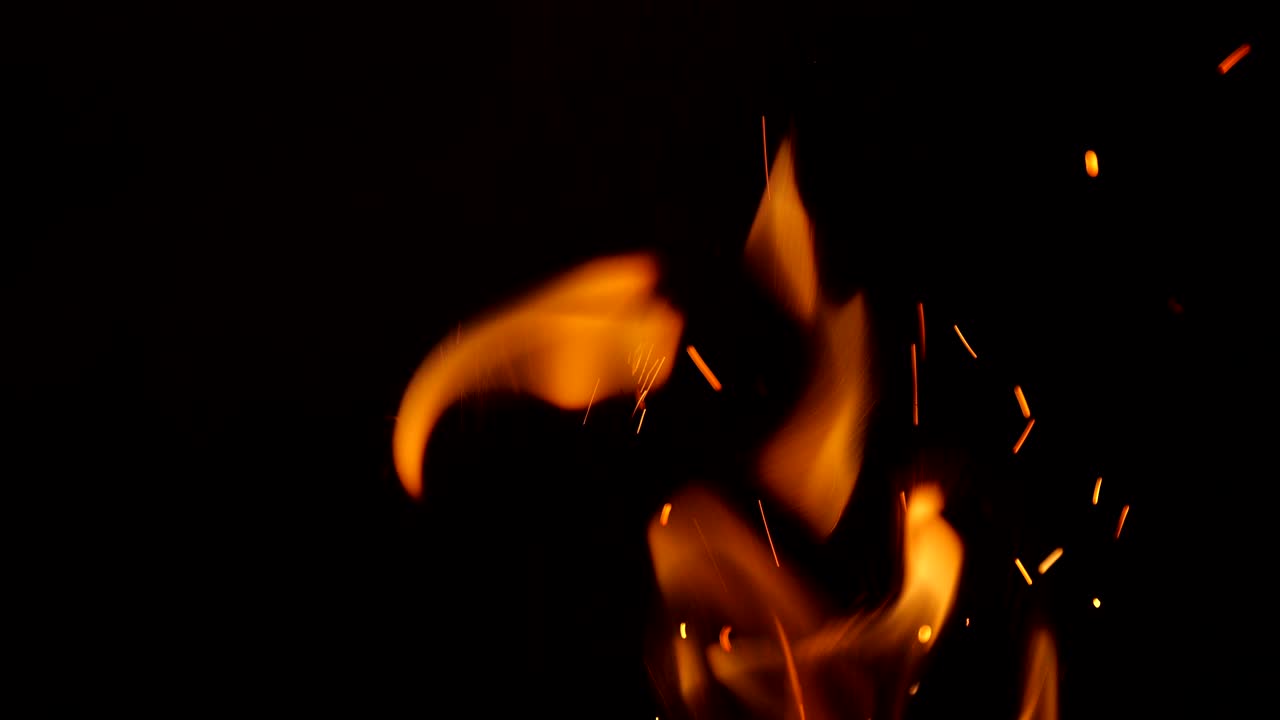 Sparkling, flying up sparkles for using in composition, vertical on black backdrop isolated. Screen mode for blending or transitions. Bright flames of fire on studio background, slow motion 50 fps 4k
