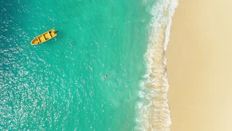 aerial view of woman swimming in beautiful clear turquoise water in indonesia