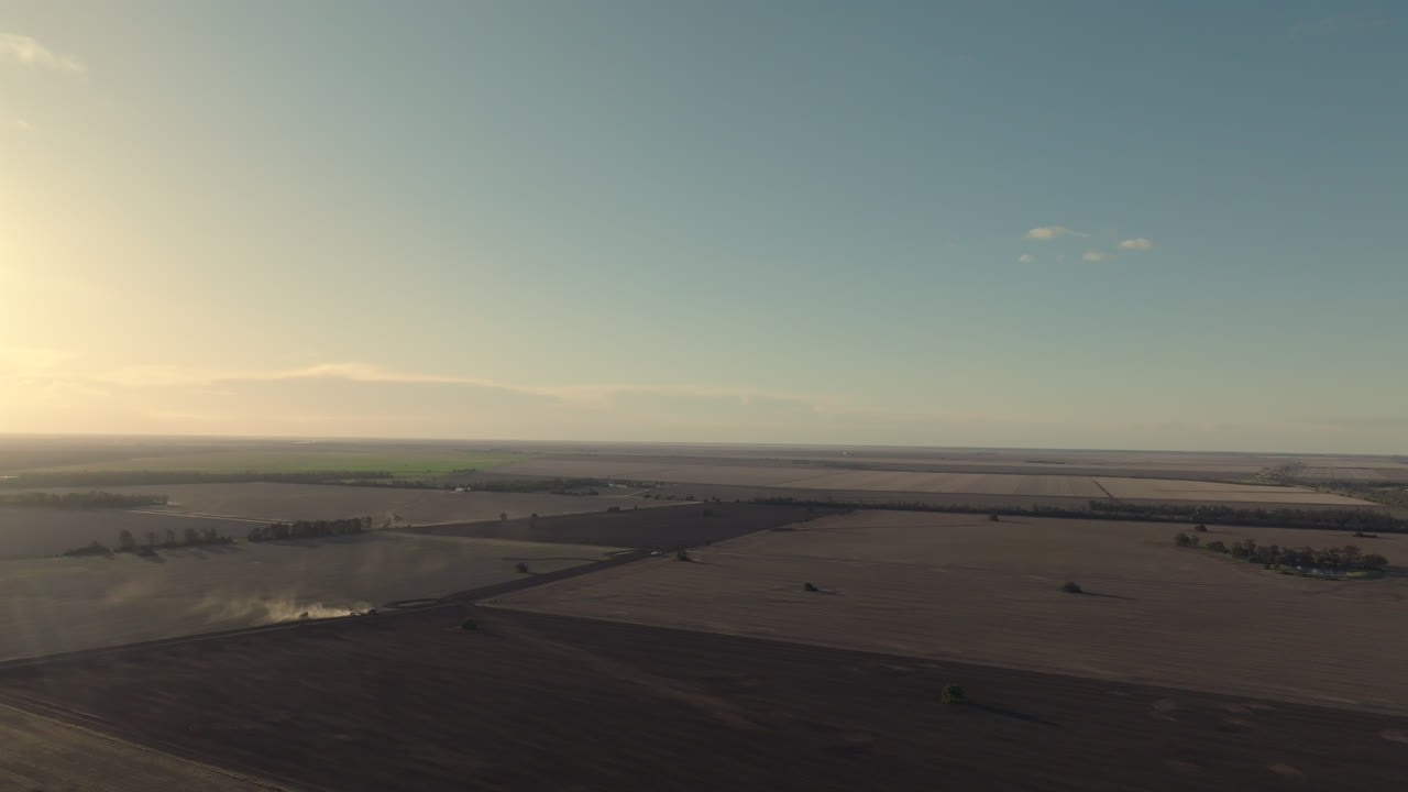 Drone shot showing a tractor working in dusty barren fields near Moree, New South Wales, Australia