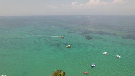 órbita-Aérea-Sobre-El-Paisaje-Marino-Turquesa-Con-Barcos-Turísticos-En-La-Costa-De-Sidari,-Isla-De-Corfú,-Grecia