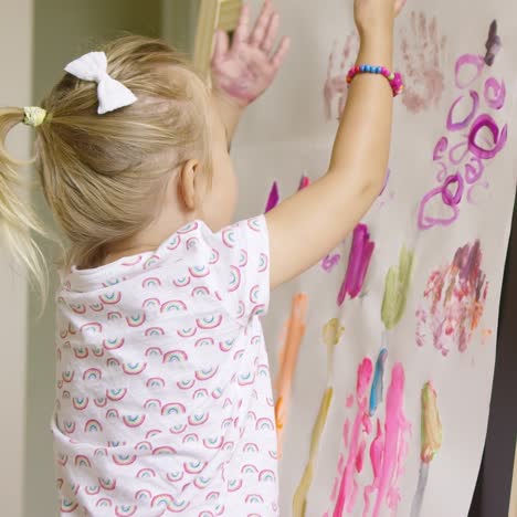 creative little girl painting an abstract picture