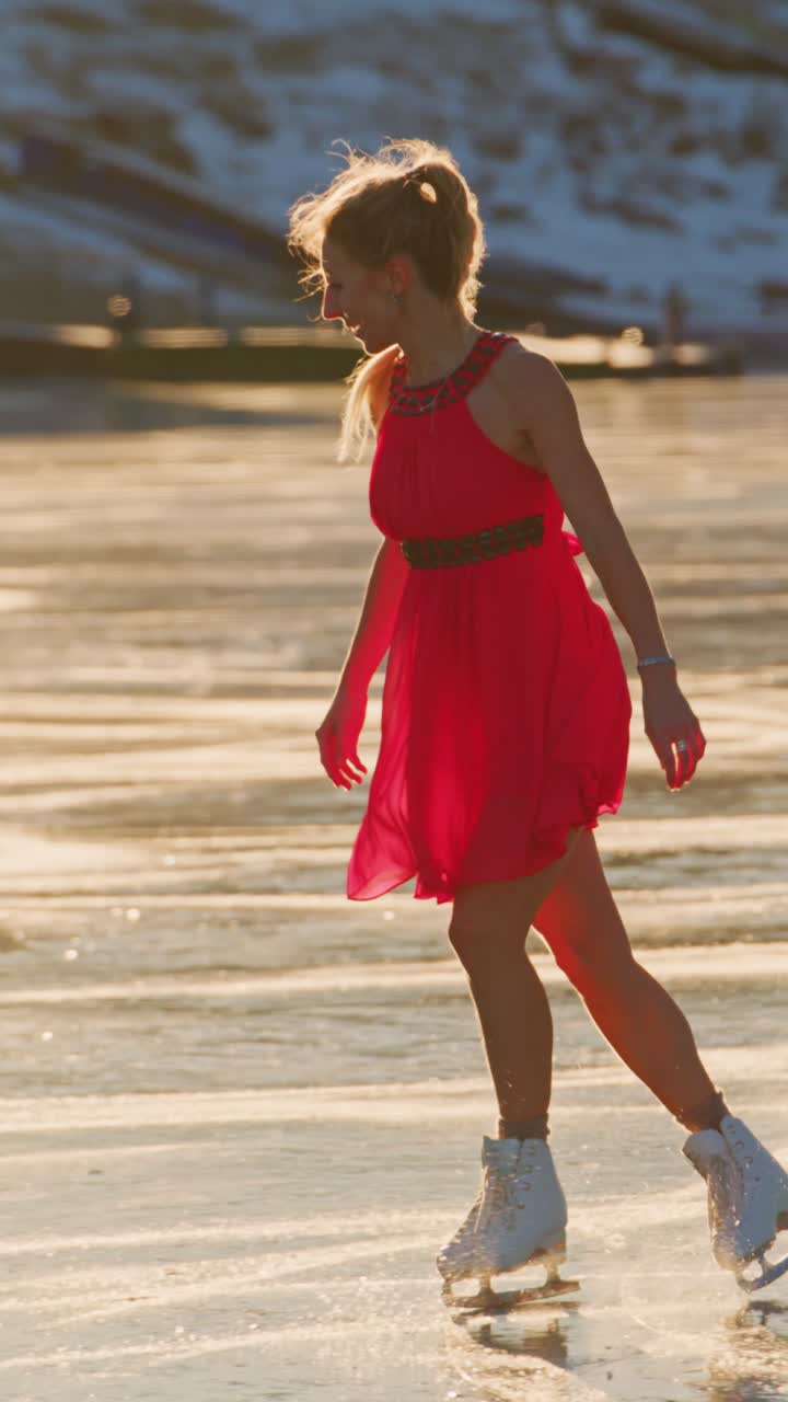 A graceful skater in a vibrant red dress glides effortlessly across a shimmering ice surface, capturing the essence of winter elegance amidst a serene frozen landscape, surrounded by soft sunlight and glistening snow