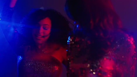 cerca de dos mujeres en un bar de club nocturno o discoteca bailando con luces brillantes 7