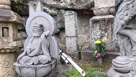 stone statues wearing a face mask at a japanese temple in onomichi