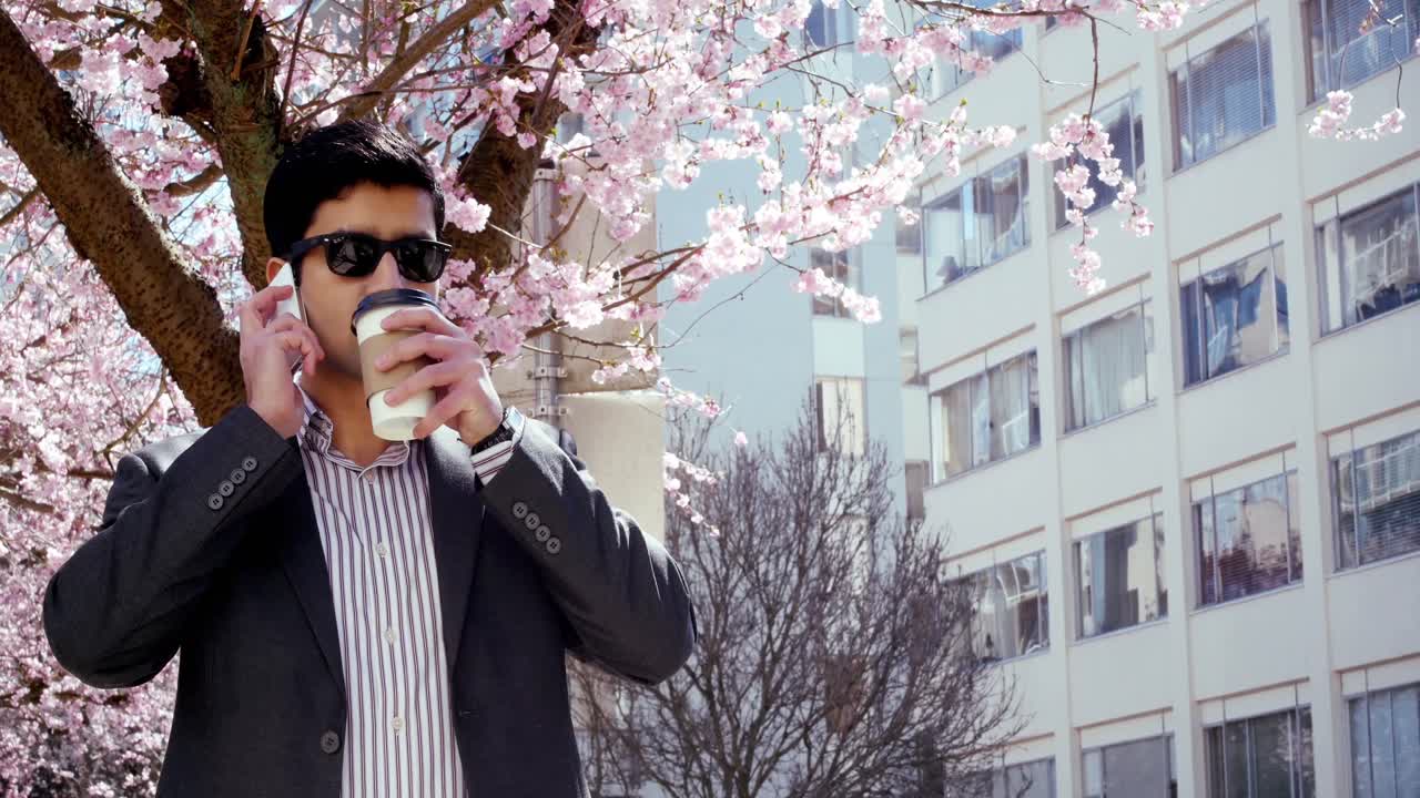 공원 4k에서 휴대 전화로 이야기하는 사업가